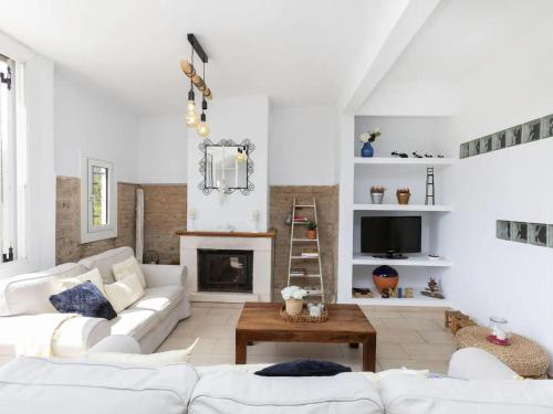 a living room with white furniture and a fireplace at CASA CANYET con piscina a un paso de Barcelona y la playa in Badalona