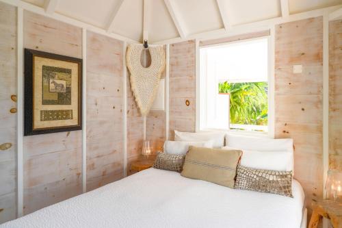 um quarto com uma cama branca e uma janela em One bedroom bungalow with shared pool terrace and wifi at Saint Barthelemy em Saint Barthelemy