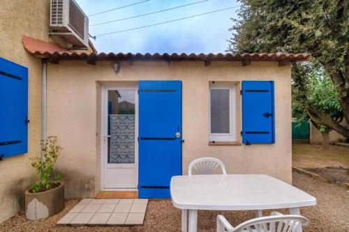 a small house with blue doors and a table at Bourgarel in Vidauban