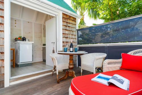 um pátio com uma cama e uma mesa com cadeiras em One bedroom bungalow with shared pool terrace and wifi at Saint Barthelemy em Saint Barthelemy