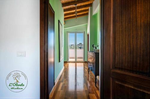 a hallway with green walls and wooden floors and a door at Oliveto Relax Alloggio Turistico in Rome
