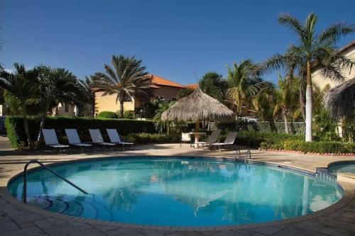 a large swimming pool with chairs and palm trees at Beautiful 4 bedroom house in gold coast in Palm-Eagle Beach