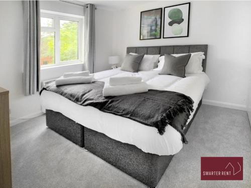 a bedroom with a large bed with white and gray pillows at Bracknell - 1 Bedroom House With Garden in Bracknell