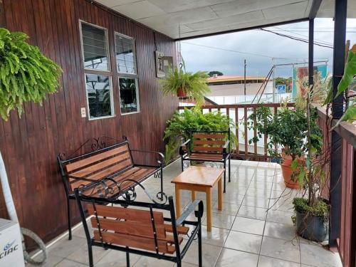 un porche con bancos y una mesa en el balcón en Cabinas Carolina, en Puerto Jiménez