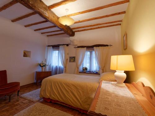 a bedroom with a bed with a lamp and windows at The Granary Ruthwaite in Uldale