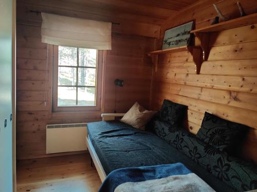 a bedroom with a bed in a log cabin at Kivakko Saariselän paratiisi - Oma ranta & sauna in Saariselka