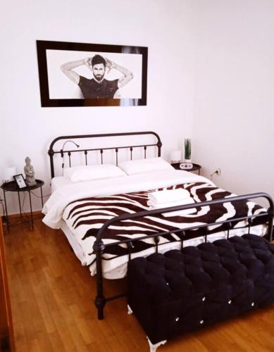 a black and white bed in a white bedroom at Nicko’s room in Piraeus