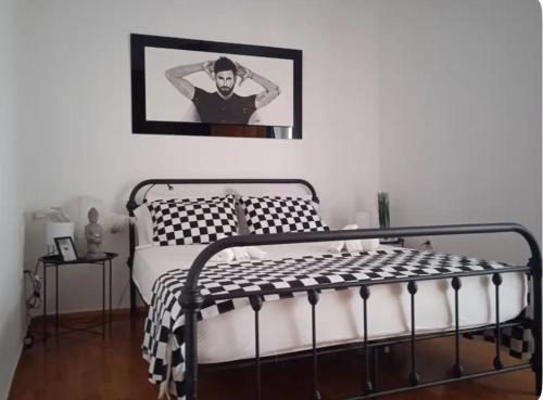 een slaapkamer met een bed en een foto van een man bij Nicko’s room in Piraeus