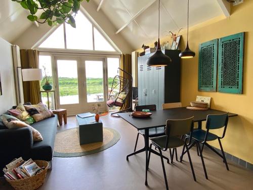 een woonkamer met een tafel en stoelen bij Romantic Dutch hideaway in Jisp