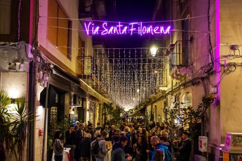 a crowd of people walking down a street at night at FilHome 44 in Catania