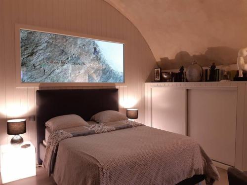 um quarto com uma cama e uma televisão por cima. em un petit nid douillet em Beauchastel