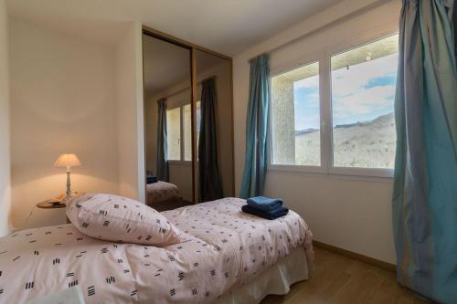une chambre avec un lit et une grande fenêtre dans l'établissement Domaine de Balesta, à Roquefort-sur-Garonne
