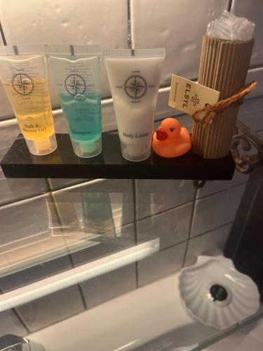 a shelf with four bottles of moisturizers and a rubber duck at B&B De Koog Texel in De Koog