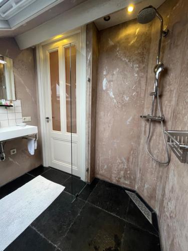 a bathroom with a shower and a glass door at B&B De Koog Texel in De Koog