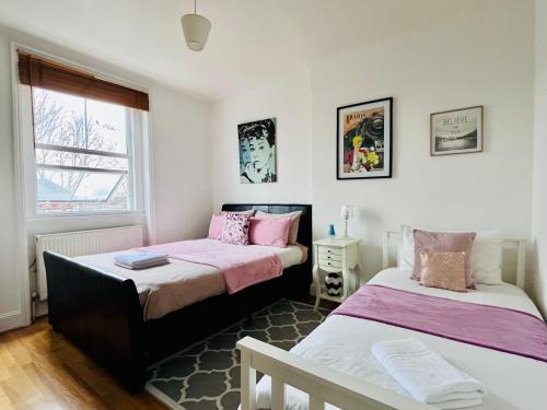 a bedroom with two beds and a window at Gorgeous Studio 15 Minutes from Central London in London