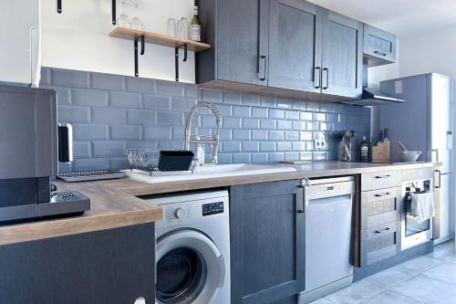une cuisine avec un évier et une machine à laver dans l'établissement Elégant avec terrasse vue mer, à Antibes