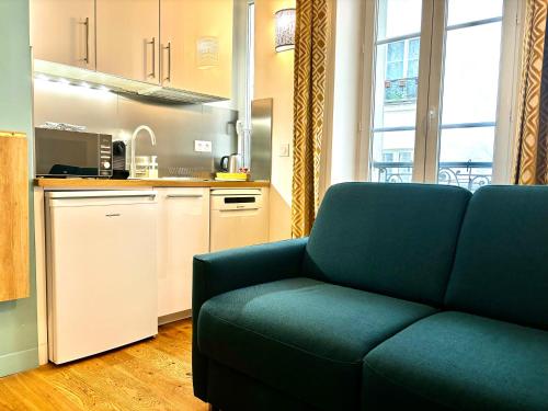 uma sala de estar com um sofá e uma cozinha em Lovely studio in the Heart of St Germain-des-Prés em Paris