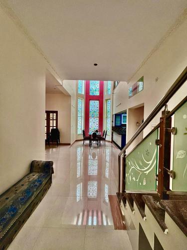 a large living room with a staircase and a large window at The Ruby Park in Yelagiri