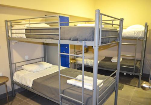 a room with three bunk beds in a room at Rooms DP Setúbal in Setúbal