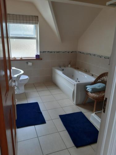 een badkamer met een bad, een toilet en een wastafel bij KYLEARD Ryan in Monasterevin