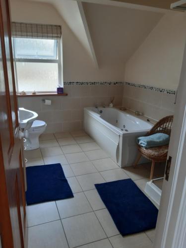 a bathroom with a tub and a toilet and a sink at KYLEARD Ryan in Monasterevin