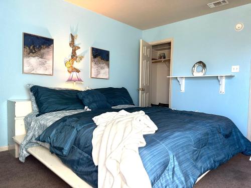 een slaapkamer met blauwe muren en een bed met blauwe lakens bij Casa Nicholas , 3 bedroom/ 2 bath with large yard in Killeen