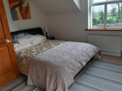 a bedroom with a bed and a window at KYLEARD Ryan in Monasterevin