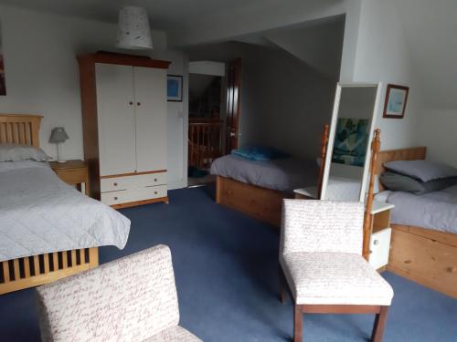 a bedroom with two beds and two chairs at KYLEARD Ryan in Monasterevin