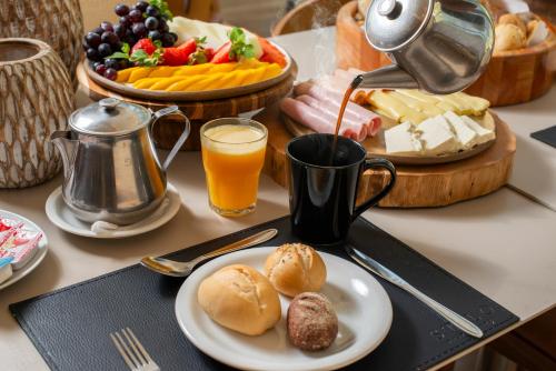 a table with a plate of food and a drink at Laghetto Stilo Barra in Rio de Janeiro