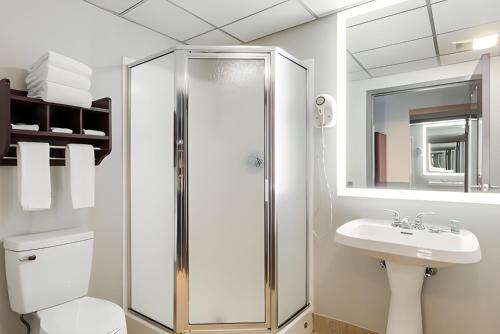 a white bathroom with a shower and a sink at Best Western Burlington Inn in Westampton Township