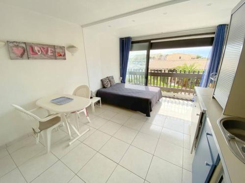 une chambre avec un lit, une table et une fenêtre dans l'établissement Studio 106, Port Vénus au village naturiste, au Cap d'Agde