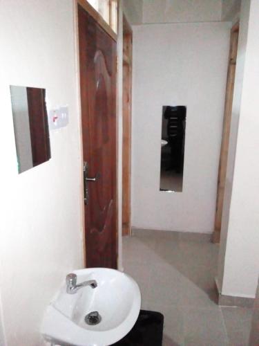 a bathroom with a sink and a wooden door at Selitah Apartments in Kitale