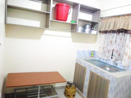 a small kitchen with a sink and a table at Selitah Apartments in Kitale