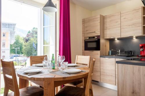 a kitchen and dining room with a wooden table with chairs at CARPATES Annecy Rent Lodge in Annecy