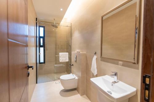 La salle de bains est pourvue de toilettes, d'un lavabo et d'une douche. dans l'établissement Riyadh Boulevard Luxury Apartment, à Riyad