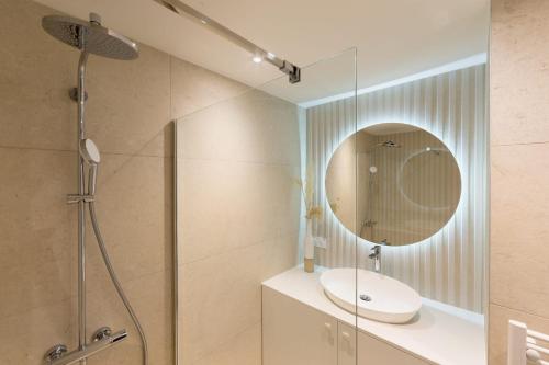 une salle de bain avec une douche, un lavabo et un miroir dans l'établissement Le Santorin élégant calme parking, à Annecy