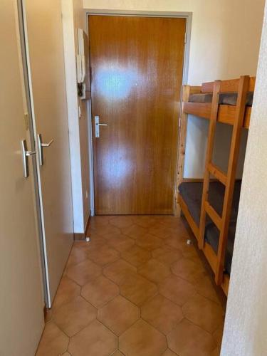 un couloir avec une porte et une chambre avec des lits superposés dans l'établissement Studio cabine climatisé, à Sanary-sur-Mer