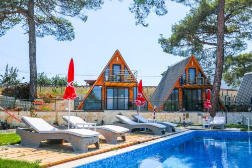 a swimming pool with lounge chairs and a house at Kandybos Eco Farm Village in Kas