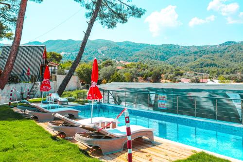 a swimming pool with lounge chairs and umbrellas at Kandybos Eco Farm Village in Kas