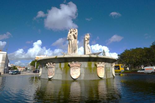 a fountain with two statues on it in the water at Suites DP Setúbal in Setúbal