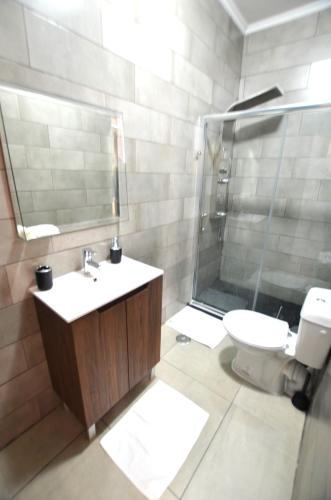 a bathroom with a shower and a sink and a toilet at Suites DP Setúbal in Setúbal