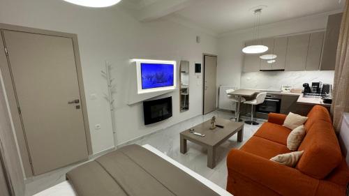 sala de estar con sofá naranja y cocina en breath studio, en Giannitsa
