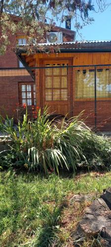 a house with a fence and some plants in the yard at Departamento Anita in El Hoyo