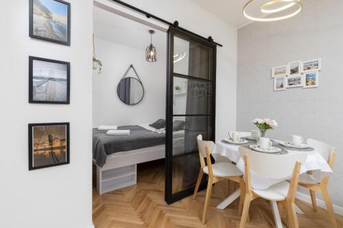 a dining room with a bed and a table and chairs at Gdynia Główna Apartament in Gdynia