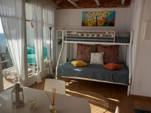 a small room with a bunk bed and a table at LOFT CANET DE MAR CERCA de BARCELONA in Canet de Mar