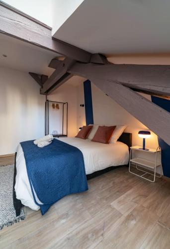 une chambre avec un grand lit dans un grenier dans l'établissement Les Stins - Appartements climatisés - centre ville, à Vichy
