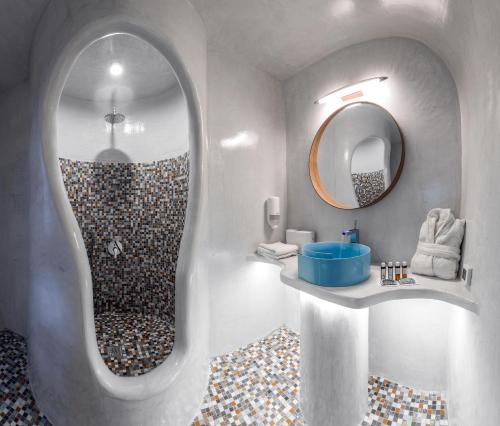 W łazience znajduje się prysznic z okrągłym lustrem. w obiekcie Elite Luxury Suites w mieście Oia
