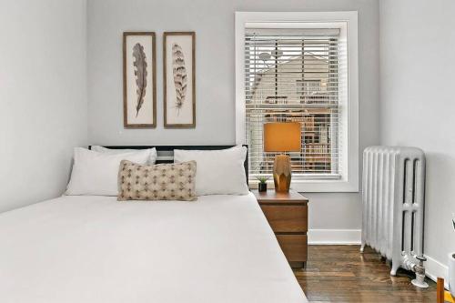 a bedroom with a white bed and a window at Great Value Lakeview 2-Bedroom Condo - Oakdale E2 E1 rep in Chicago
