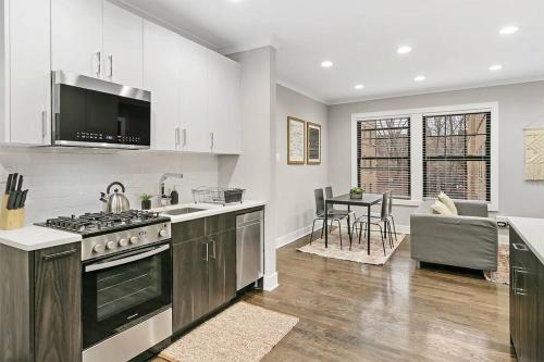 a kitchen with a stove top oven next to a living room at Great Value Lakeview 2-Bedroom Condo - Oakdale E2 E1 rep in Chicago