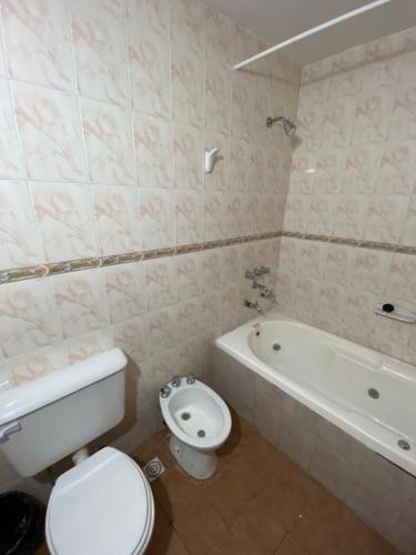 ein Badezimmer mit einem WC, einer Badewanne und einem WC in der Unterkunft Cabañas los álamos in Termas de Río Hondo